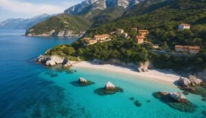 Coastal village with beach, turquoise water, and mountains in the background