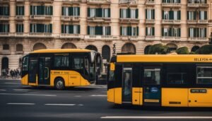 Two yellow and black buses on a city street with a building background
